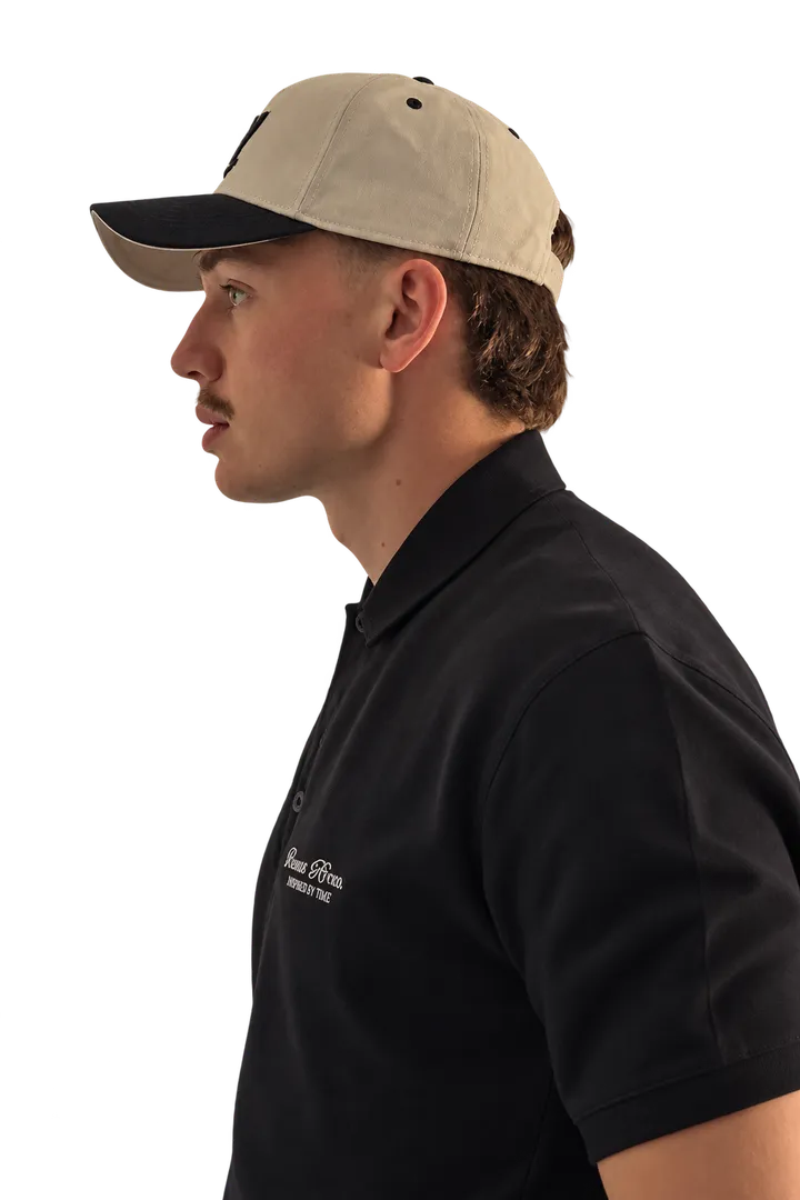 Markus Fourie in profile, wearing a cap and a dark polo shirt